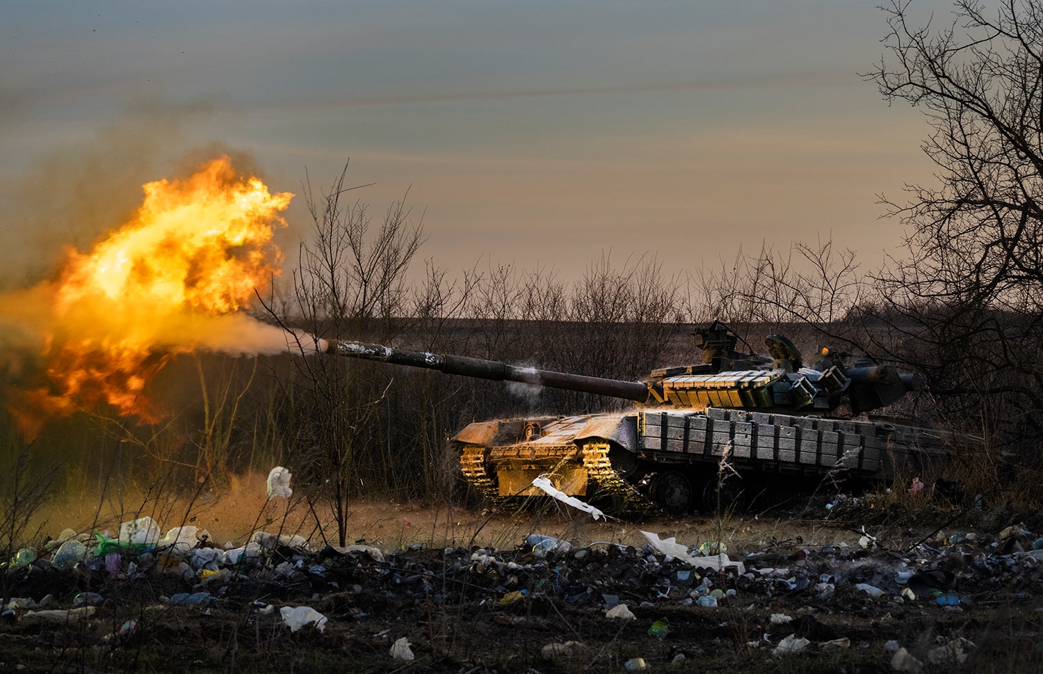 En ukrainsk tanks beskyter russiske stillinger i en krig der ukrainerne sårt trenger våpenhjelp for å holde ut mot den russiske offensiven. 