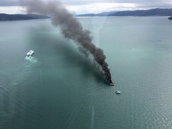 Person hoppet over bord fra brennende båt