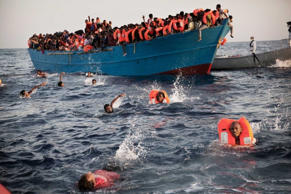 Arkivfoto fra 2016. Migranter, de fleste fra Eritrea, hopper i vannet under en redningsoperasjon i Middelhavet utenfor kysten av Libya. 