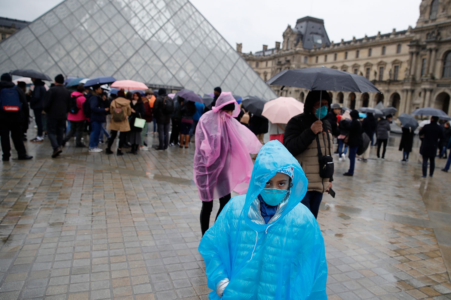 Turister med ansiktsmasker går bort fra inngangen til Louvre-museet i Paris etter at de ansatte nekter å jobbe av frykt for å bli smittet av koronaviruset.